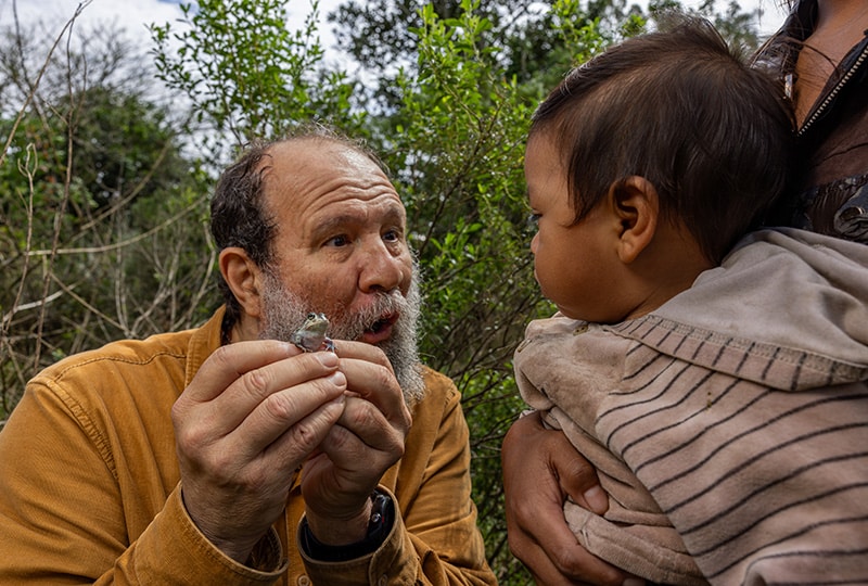 Alexandre showing a young child a frog