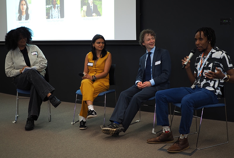 Three CEOs on a panel being questioned by a student leader