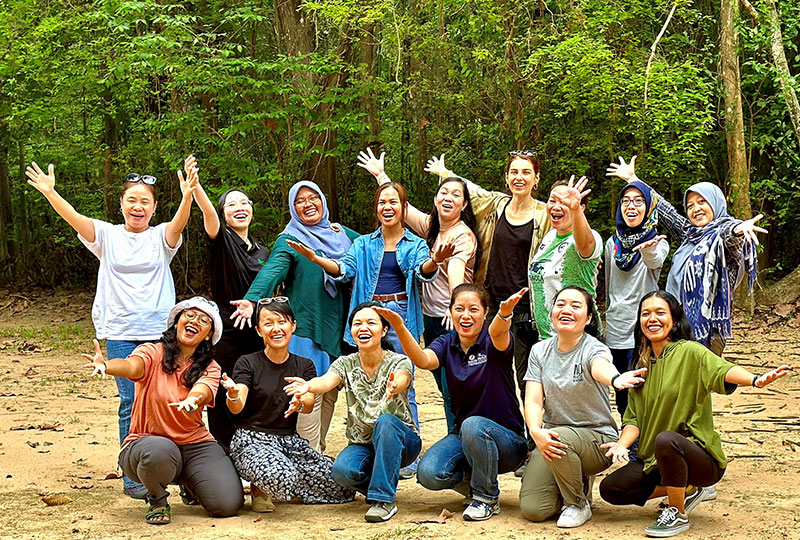 Women who took part in ASAP's Women in Conservation leadership programme smiling with outstretched arms