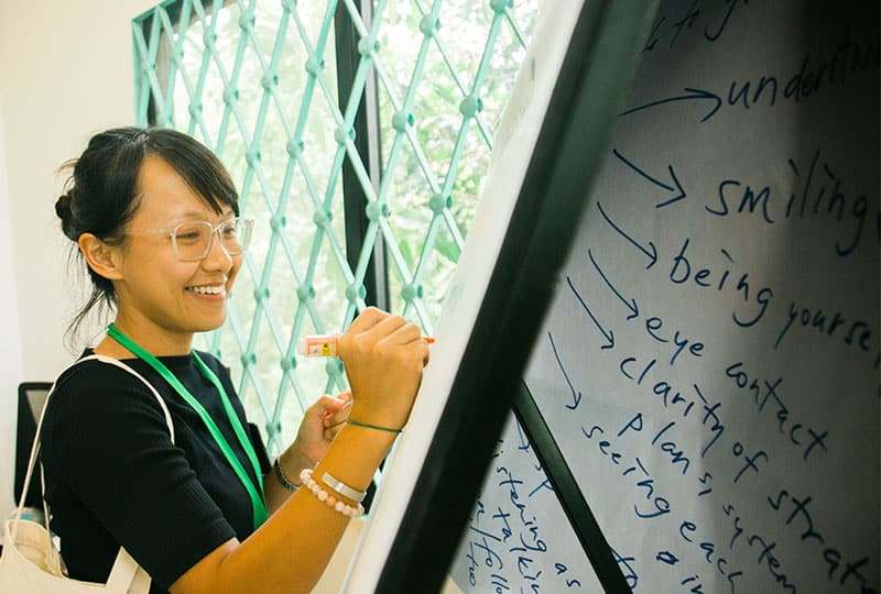 A woman writes on a whiteboard