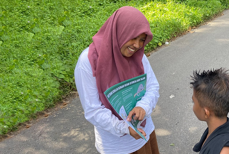 Woman talking to young child with poster